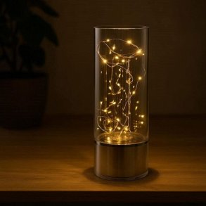Et stemningsfuldt billede af en t�ndt LED-spejlvase i et m�rkt rum, hvor infinity-lyseffekten kaster et varmt og hyggeligt sk�r over en tr�overflade.