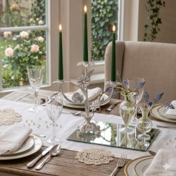 lysestage-fransk-landstil-blomster-milj�-chic-antique Romantisk fransk lysestage med tre m�rkegr�nne stagelys p� en spejlplade midt p� et d�kket bord med krystalglas og sm� vaser med bl� blomster.