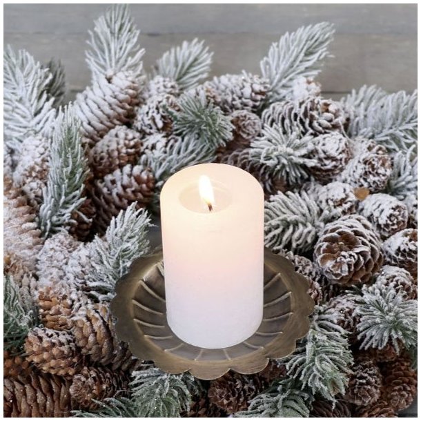 Antik messing lysholder med spyd monteret med et t�ndt hvidt bloklys i en sned�kket krans af grangrene og kogler.