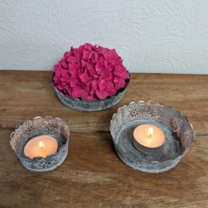 S�t af tre antik gr� metalfade placeret p� et tr�bord, hvor det st�rste fad indeholder en pink hortensia og de to mindre fade har t�ndte fyrfadslys.