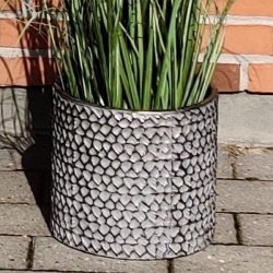 En lille cylinderformet urtepotte i rustfrit metal med pr�get s�lv og sort m�nster. St�rrelse: H23,5 x D25 cm.