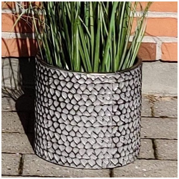 En lille cylinderformet urtepotte i rustfrit metal med pr�get s�lv og sort m�nster. St�rrelse: H23,5 x D25 cm.