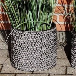 En stor cylinderformet urtepotte i rustfrit metal med pr�get s�lv og sort m�nster. St�rrelse: H26,5 x D30 cm.