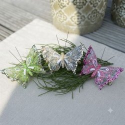 Tre dekorationssommerfugle i organza (gr�n, champagne og rosa) med glimmer og hvide aftegninger samlet p� en gr�n gren.