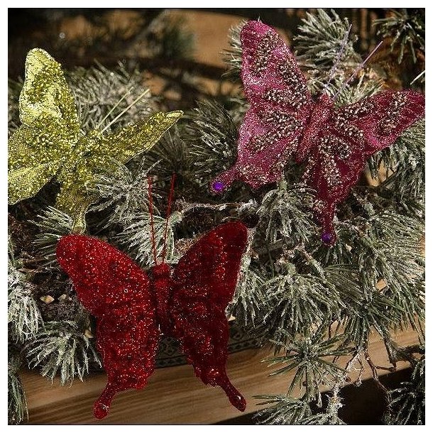 Tre organza sommerfugle i gr�n, r�d og fuchsia med glimmer placeret p� t�tte grangrene.