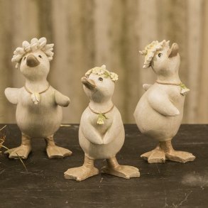 Tre forskellige st�ende p�ske�llinger i polyresin med blomsterkranser p� 11,7 cm.