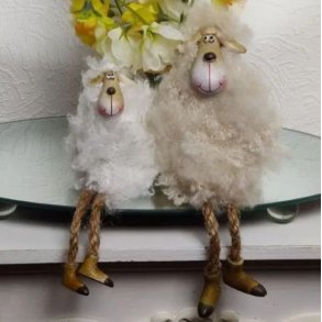 To s�de p�skef�r i forskellige st�rrelser, der sidder sammen p� en hvid kant foran gule for�rsblomster.