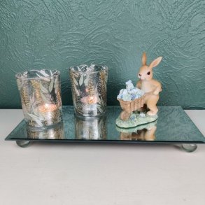 Detaljeret p�skefigur med en hare og trilleb�r i en hyggelig opstilling p� en spejlbakke, velegnet til p�skebordet.