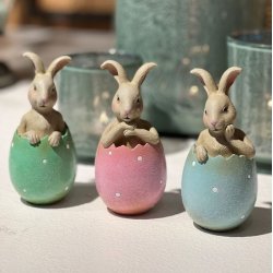 Lille p�skehare i lyser�d �ggeskal placeret dekorativt sammen med for�rsblomster og p�skepynt