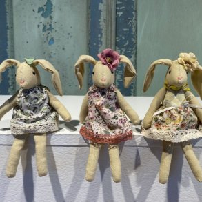 Tre siddende p�skeharer i vintagestil med m�nstrede bomuldskjoler i en lys opstilling.