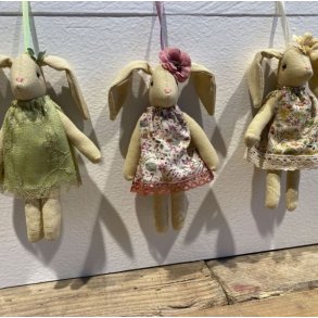 Tre siddende p�skeharer i vintagestil med hver deres m�nstrede stofkjole i en for�rsopstilling.