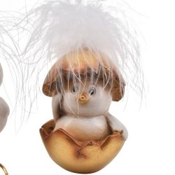 Fritlagt figur af en hvid p�skekylling med bl�de fjer, der sidder nede i en guld�ggeskal.