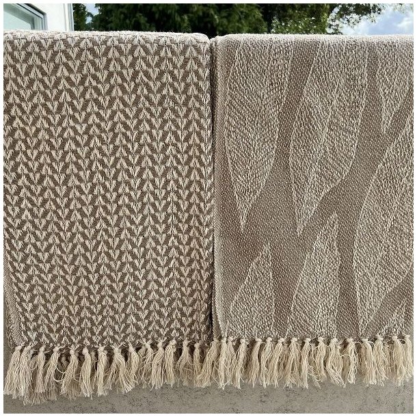 De to beige bomuldsplaider med frynser vist sammen, s� man kan se de to forskellige m�nstre.