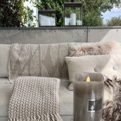 De to beige m�nstrede plaider draperet over rygl�net p� en lys sofa for at skabe en hyggelig stemning.