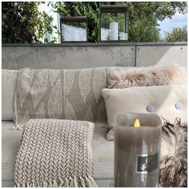 De to beige m�nstrede plaider draperet over rygl�net p� en lys sofa for at skabe en hyggelig stemning.