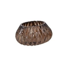 retro-fyrfadsstage-glas-moerkebrun En fritlagt rund fyrfadsstage i kraftigt gennemsigtigt glas i en dyb m�rkebrun retrofarve. Vasen eller stagen har et gennemg�ende, pr�get rillem�nster og en stabil, tyk glasbund. St�rrelse: H6 / D10,5 cm.