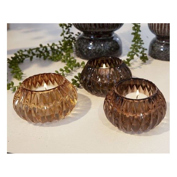 retro-fyrfadsstager-brune-glas-tre-nuancer Tre m�nstrede retro fyrfadsstager i brunt, gennemsigtigt glas st�ende samlet p� et lyst bord. Nuancerne sp�nder harmonisk fra en m�rk chokoladebrun over en varm mellembrun til en lys, gyldenbrun variant. St�rrelse: H6 / D10,5 cm.
