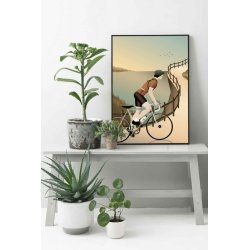 retro-plakat-cycling-the-hills-miljoe Et lyst, skandinavisk milj�billede, hvor plakatmotivet med cykelrytteren i bjergene h�nger indrammet i en lys tr�ramme p� en hvid v�g over en minimalistisk sk�nk. Dagslyset str�mmer ind fra siden og fremh�ver de harmoniske, d�mpede pastelfarver.