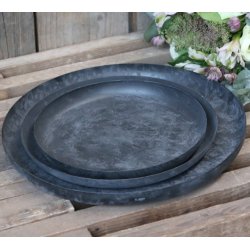 S�t med tre runde sorte metalfade i forskellige st�rrelser stablet p� en tr�bakke med blomster i baggrunden.