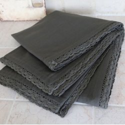 En t�t optagelse af den m�rkegr� dug, der ligger p�nt sammenlagt, s� man kan se den tydelige h�r-struktur og blondekanten.