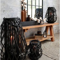 Et flot opstilling med de tre sorte fletlanterner i pil (lille, mellem, stor) p� en rustik tr�b�nk.