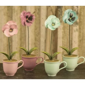 Oversigtsbillede af alle fire farvevarianter af stedmoderblomster i kopper i polyresin.