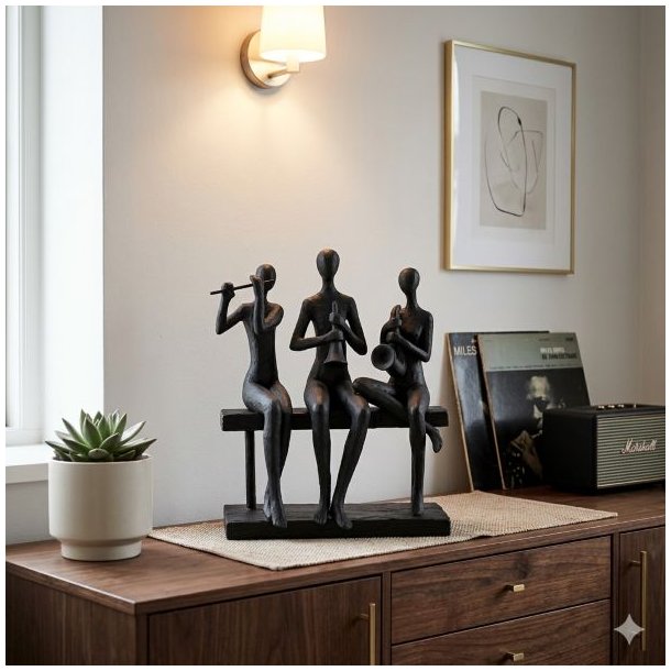 Et stilfuldt indend�rs milj�billede af en m�rk, stiliseret figur i polyresin, der forestiller tre musikere, der sidder p� en b�nk og spiller fl�jte, obo og saxofon. Skulpturen er placeret centralt p� en m�rk tr�sk�nk, flankeret af en sukkulentplante, vinylplader og en retro-h�jttaler, under det varme sk�r fra en v�glampe.