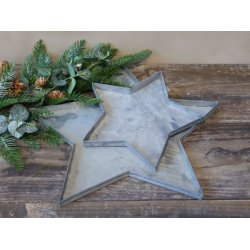 To stjerneformede fade i antik zink i st�rrelserne �40 cm og �24 cm vist p� tr�bord.