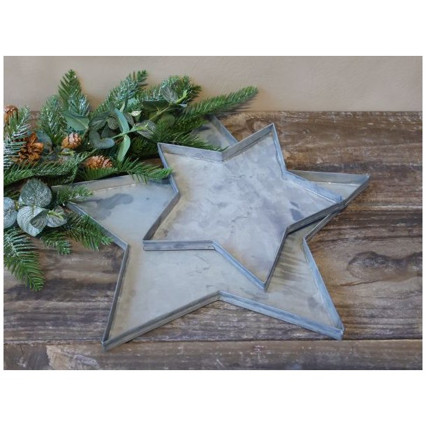 To stjerneformede fade i antik zink i st�rrelserne �40 cm og �24 cm vist p� tr�bord.