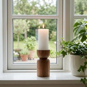 Lysestage i naturtr� med et t�ndt hvidt bloklys st�ende i en vindueskarm ved siden af en gr�n plante.