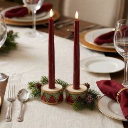 Stemningsfuldt firkantet milj�billede af to r�de og gr�nne tromme lysestager fra La Vida med t�ndte m�rker�de kronelys p� et smukt d�kket julebord med bordl�ber, gran og vinglas.