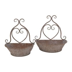 vaeg-urtepotter-sandfarvet-jern-fritlagt.jpg Fritlagt billede af to v�gh�ngte urtepotteskjulere i sandfarvet jern med hvide patinerede detaljer og hjerteformet oph�ng.