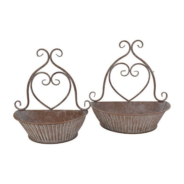 vaeg-urtepotter-sandfarvet-jern-fritlagt.jpg Fritlagt billede af to v�gh�ngte urtepotteskjulere i sandfarvet jern med hvide patinerede detaljer og hjerteformet oph�ng.