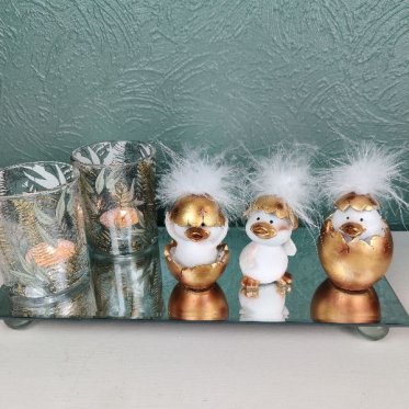p�skekyllinger i guld �g opstillet p� spejlfad med glas fyrfadsstager